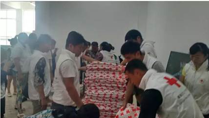 蔡甸安置点,红十字志愿者正在分发棉被